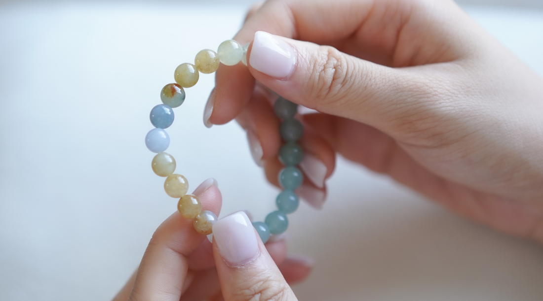 Holding a multicolour jade bracelet