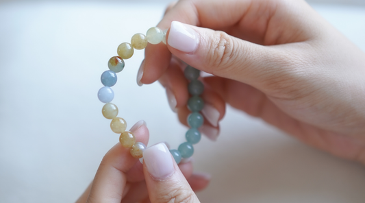 Holding a multicolour jade bracelet